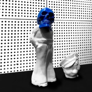 Pochette de l'album « Frozen Charlotte » de Jack White : un crâne bleu vif posé sur une figurine de porcelaine blanche