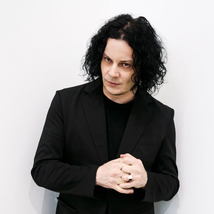 Jack White en veste noire sur fond blanc, photo officielle liée à l'album « Frozen Charlotte »